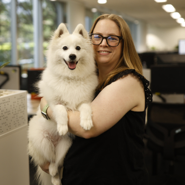 Woman holding white dog 