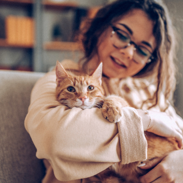 Woman sitting down, holding cat.