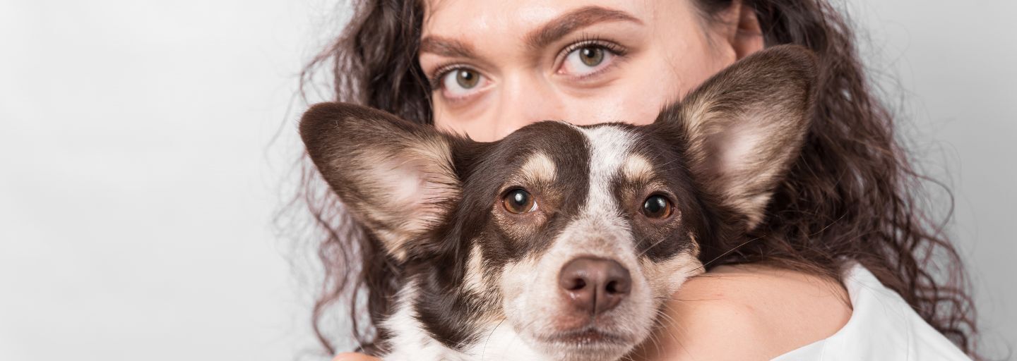 A girl with dog lying on her shoulder.