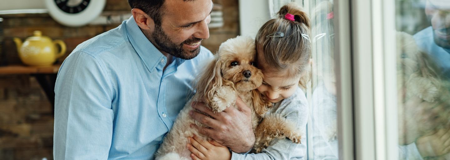 father and daughter hugging puppy
