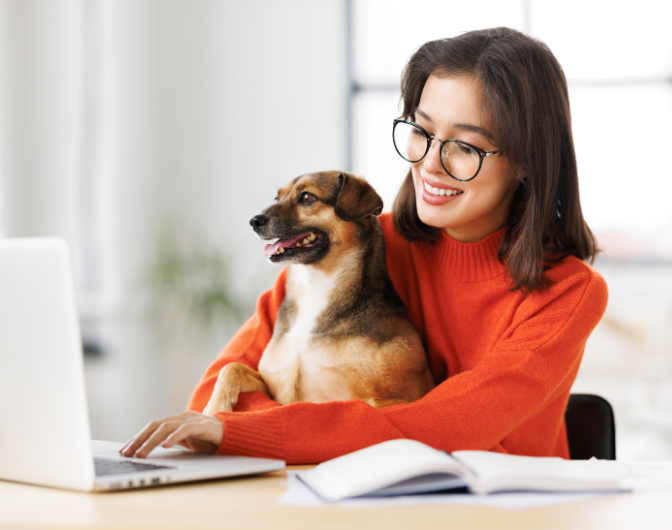 woman playing with dog in her workplace