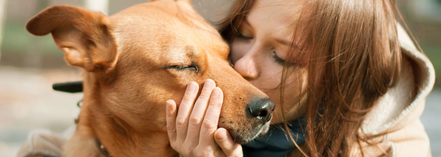 woman kissing dog