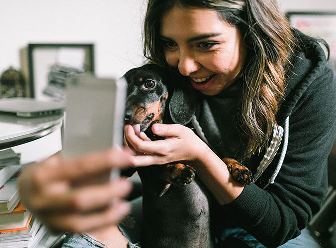 girl taking a selfie with her dog. 