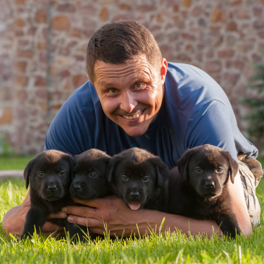 man with four puppies